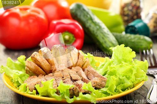 Image of Meat and potatoes on a green salad.