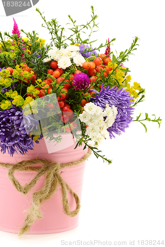 Image of Bouquet of flowers and fruit in pink bucket.