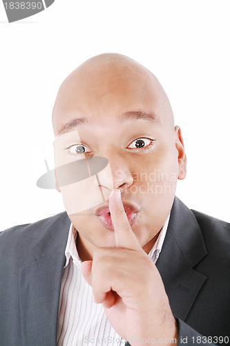 Image of Black man showing silence gesture with finger on his lips. All o