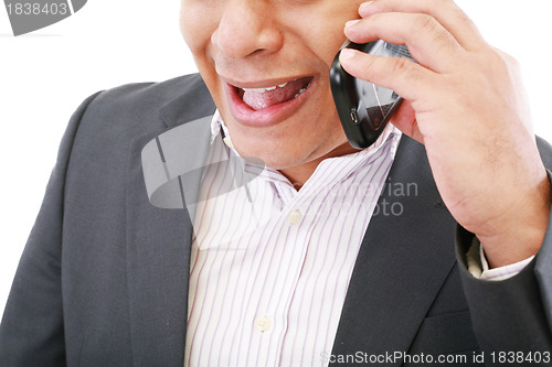 Image of  angry young male executive yelling on his mobile phone against 