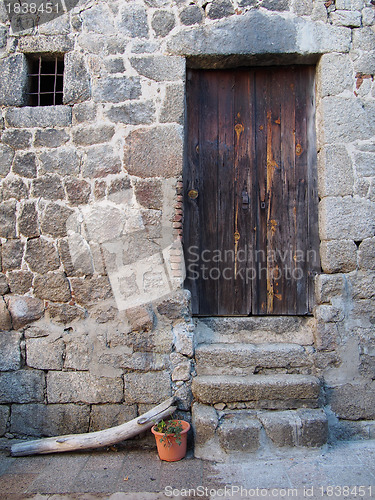 Image of mediterranean wood door and stone wall, Corsica