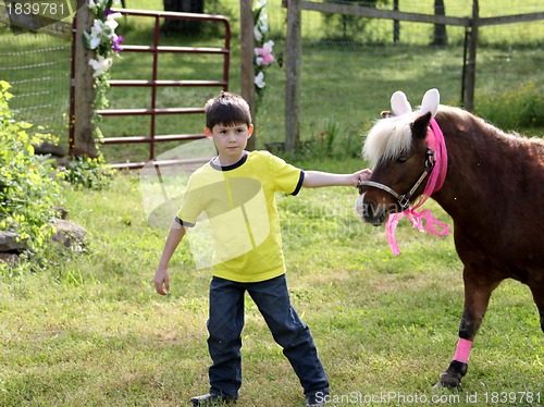 Image of Little boy with pony decorated for Easter