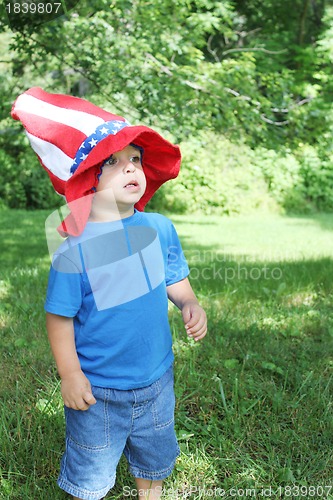 Image of Little boy wearing big 4th of July hat outside