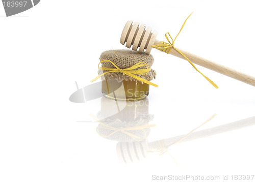 Image of Wooden honey drizzlier and a jar of honey