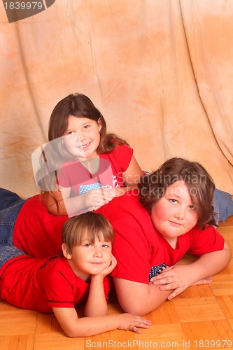 Image of Three beautiful children in red shirts
