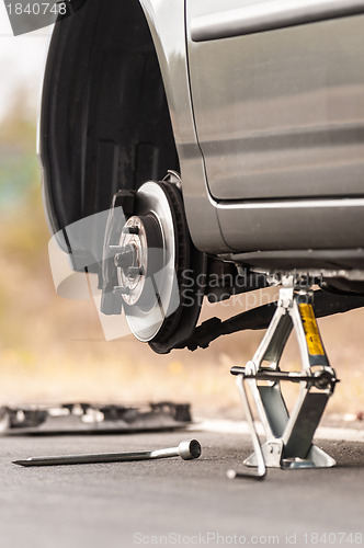 Image of Car without tire on the road