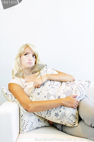 Image of Serious woman with cushion on couch