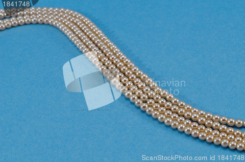 Image of Pearl collar turn closeup over blue background 