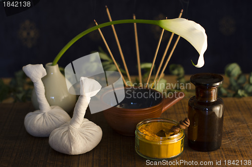 Image of An arrangement of , spice, oil and massaging tools used in Ayurv