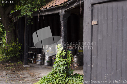 Image of A cache of metal beer barrels in a pub porch