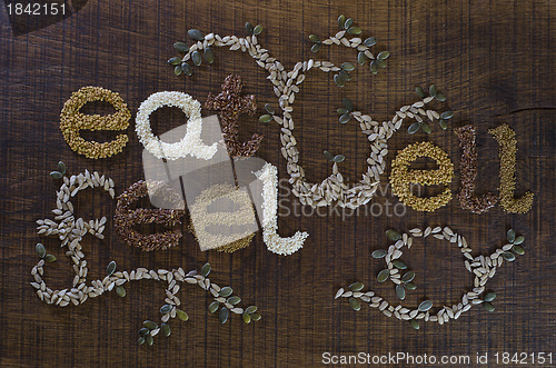 Image of The phrase 'Eat Well, Be Well', written and decorated in seeds