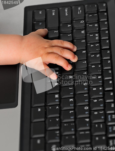 Image of Kid hand on a laptop keyboard