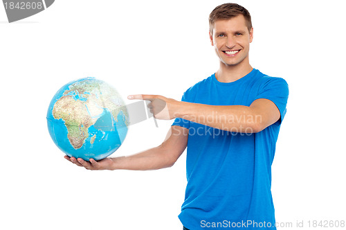 Image of Handsome young caucasian pointing at globe