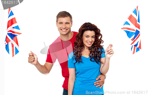 Image of Young love couple embracing and holding national flag