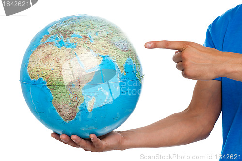 Image of A finger pointing at the globe. closeup shot