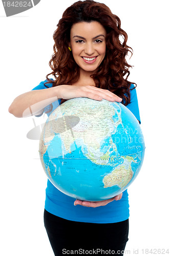 Image of Cheerful girl holding globe safely with both hands