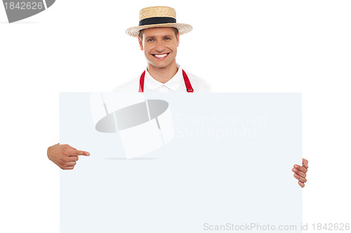 Image of Portrait of cheerful chef pointing at placard