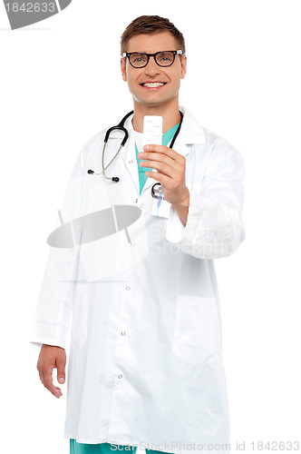 Image of Smiling doctor showing tablets pack to camera