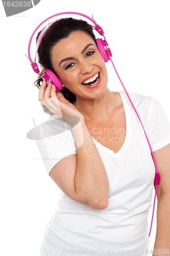 Image of Young smiling woman listening to music