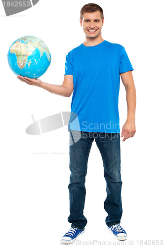 Image of Trendy casual guy posing with a globe