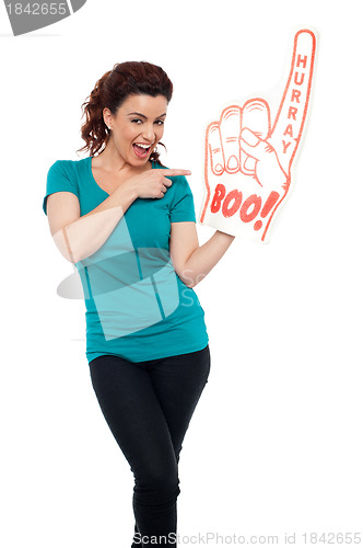 Image of Young woman pointing at large foam hand