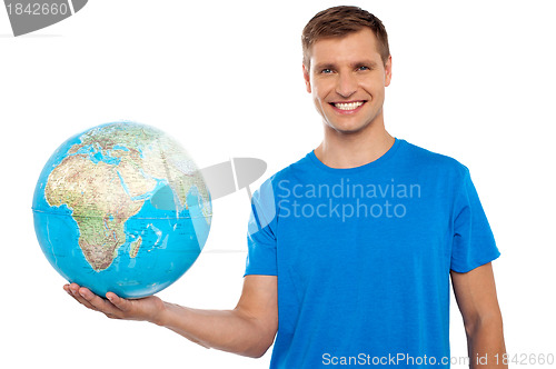 Image of Attractive young man holding globe in his hand