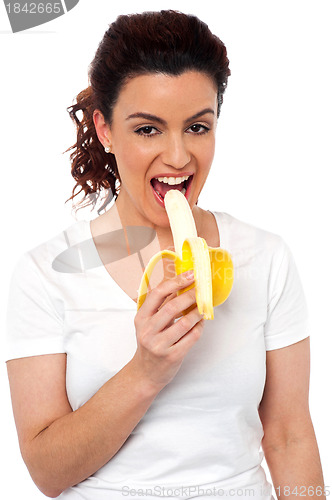 Image of Beautiful young fit girl eating banana