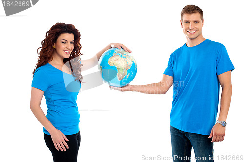 Image of Attractive young couple holding a globe together