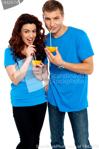 Image of Young couple drinking orange juice together