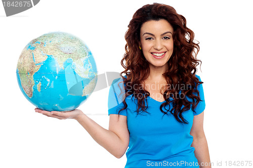 Image of Pretty smiling girl holding globe in right hand