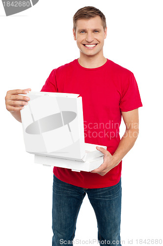 Image of Smiling casual man holding pizza box