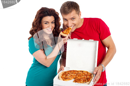 Image of Pretty woman making her boyfriend end pizza piece