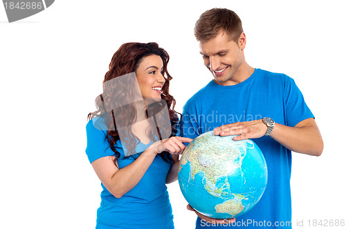 Image of Couple discussing about specific country while points at it
