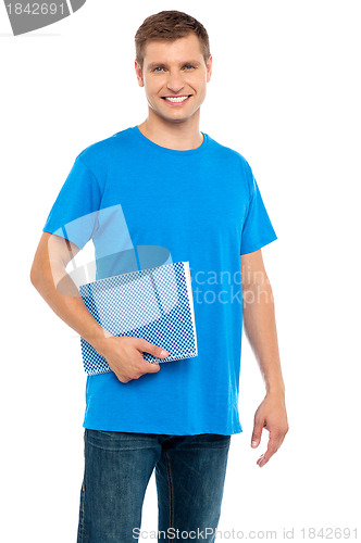 Image of Smiling guy holding spiral notebook