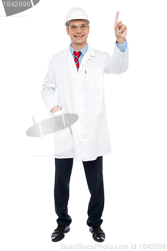 Image of Young male architect pointing at copy space