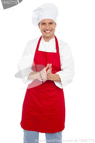 Image of Cheerful confident male chef in proper uniform