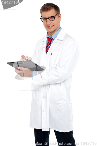 Image of Handsome doctor writing prescription