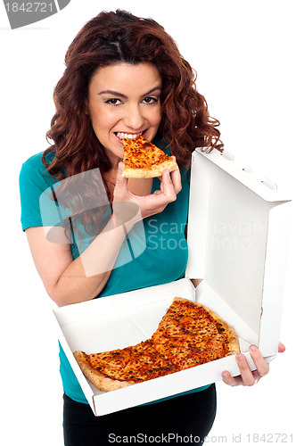 Image of Young cheerful girl enjoying pizza alone