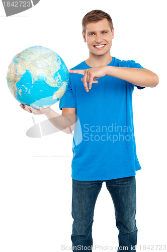 Image of Smart guy pointing at the globe. Dressed in casuals