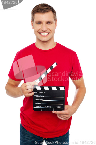 Image of Smiling young guy holding clapperboard