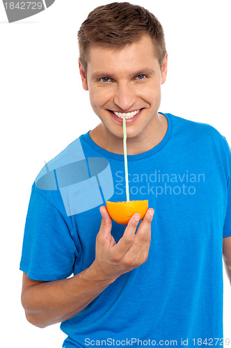 Image of Cool guy sipping juice from half orange