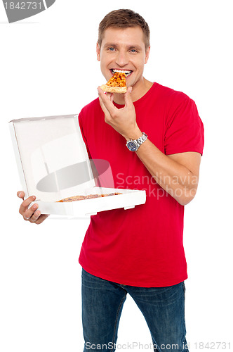 Image of Cool young guy enjoying pizza
