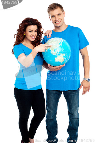 Image of Couple posing for a picture with globe in hand