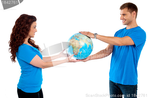 Image of Causal young couple holding globe together