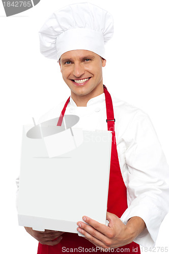 Image of Portrait of a chef holding a pastry box