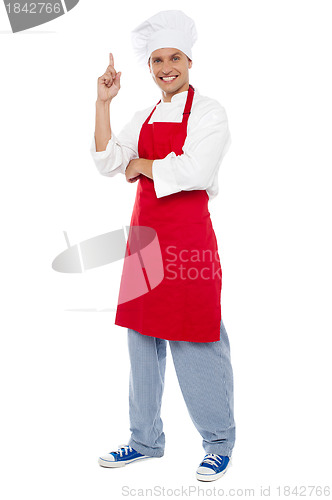 Image of Young smart chef pointing index finger upwards