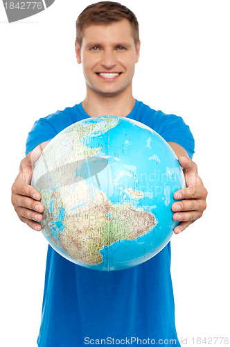 Image of Casual young guy presenting globe