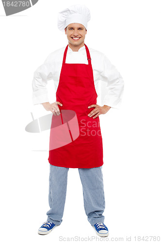 Image of Relaxed chef standing with hands on his waist