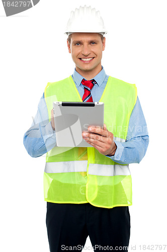 Image of Male construction engineer using tablet pc