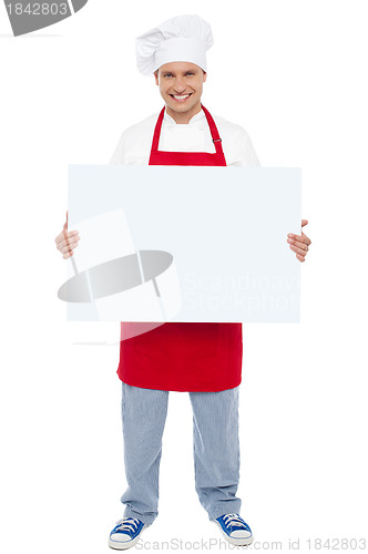 Image of Chef holding blank white billboard. Full length shot